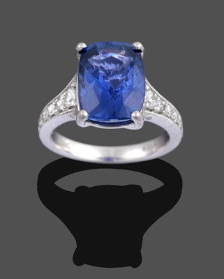 Lot 1141 - A Platinum Sapphire and Diamond Ring, the cushion cut sapphire in a four claw setting, to graduated