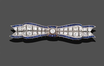 Lot 1143 - An Art Deco Diamond and Sapphire Bow Brooch, two rows of graduated diamonds bordered by...