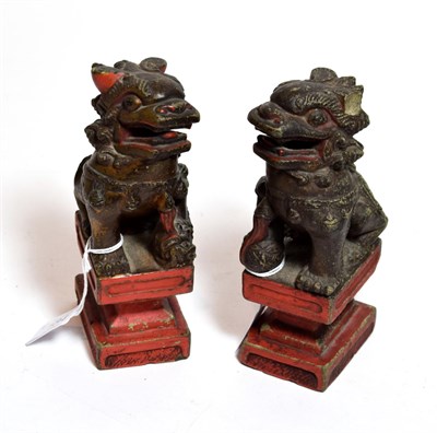 Lot 184 - A pair of Chinese temple lions on integral plinth bases, late 19th/early 20th century (2)