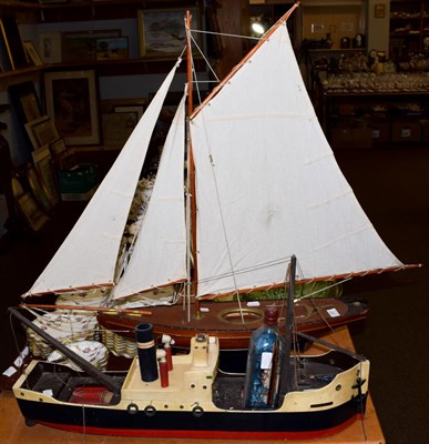 Lot 257 - A 20th century model pond yacht on stand; together with a wooden model of a ship and a ship in...