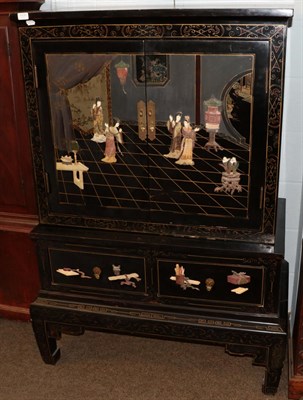 Lot 1171 - A 20th Century Chinese black lacquered and painted hard stone and bone inlaid cabinet on stand....