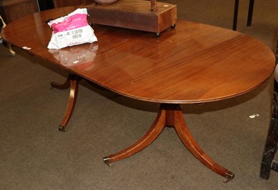 Lot 1211 - An early 20th century mahogany twin pedestal dining table with one additional leaf, 208cm fully...
