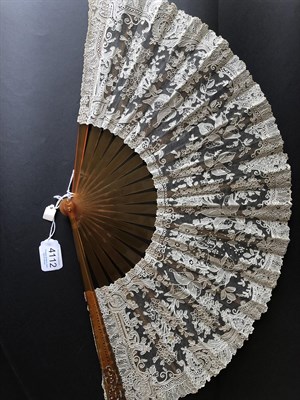 Lot 4112 - A Good Brussels Point De Gaze Needle Lace Fan, circa 1880's, the monture of amber resin, the...