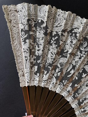 Lot 4112 - A Good Brussels Point De Gaze Needle Lace Fan, circa 1880's, the monture of amber resin, the...