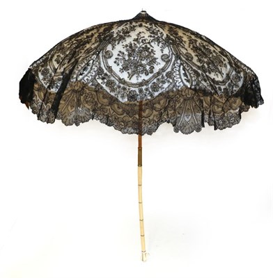Lot 4122 - An Elegant Mid-19th Century Ivory Folding Parasol, the good black Chantilly lace cover with...
