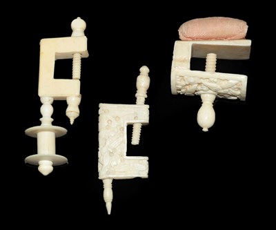 Lot 4154 - Three Small 19th Century Ivory Sewing Clamps, comprising one example with a pink pincushion, carved
