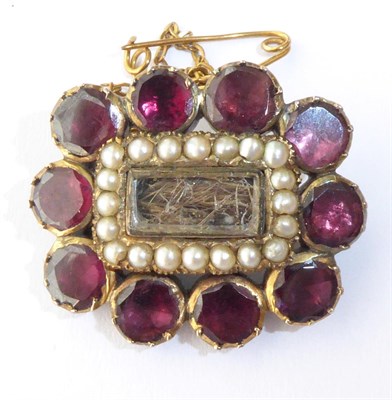 Lot 136 - A Georgian Garnet and Seed Pearl Hairwork Mourning Brooch, measures 2.5cm by 1.5cm