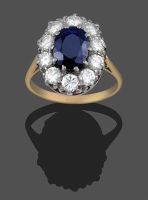 Lot 2007 - A Sapphire and Diamond Cluster Ring, the oval cut sapphire within a border of round brilliant...