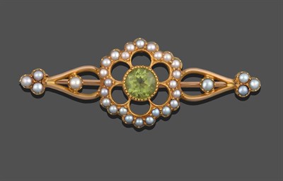 Lot 2028 - A Peridot and Seed Pearl Brooch, the central round cut peridot in a yellow millegrain setting...