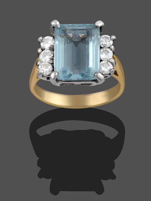 Lot 2029 - An Aquamarine and Diamond Ring, the emerald-cut aquamarine sits between trios of round...