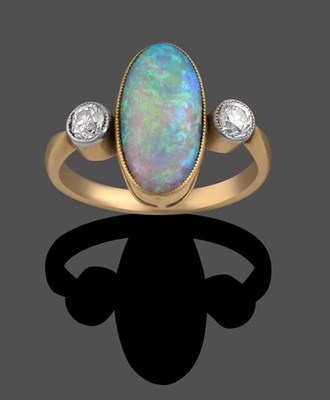 Lot 2031 - An Opal and Diamond Three Stone Ring, the oval cabochon opal in a yellow millegrain setting flanked