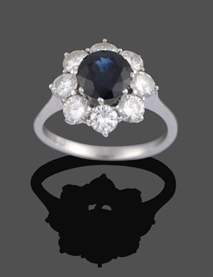 Lot 2041 - A Sapphire and Diamond Cluster Ring, the central round cut sapphire within a border of round...