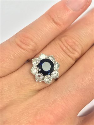 Lot 2041 - A Sapphire and Diamond Cluster Ring, the central round cut sapphire within a border of round...