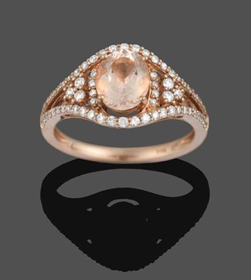 Lot 2047 - A Morganite and Diamond Ring, the central oval cut morganite flanked by stepped round brilliant cut