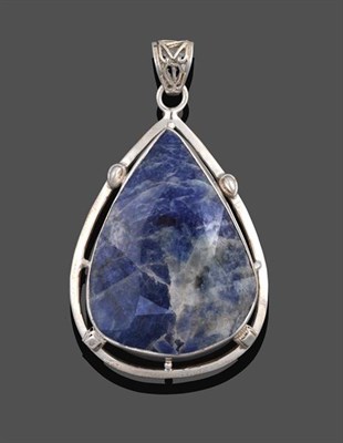 Lot 2054 - An Iolite Pendant, the pear cut iolite in a white rubbed over setting to a fancy border,...