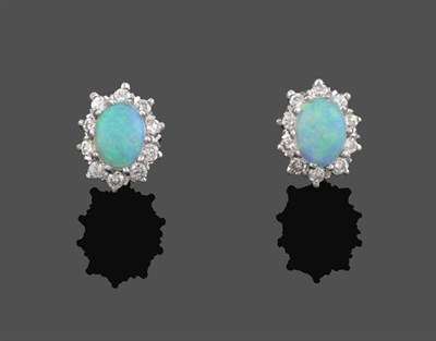 Lot 2063 - A Pair of 9 Carat Gold Opal and Diamond Cluster Earrings, an oval cabochon opal within a border...