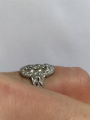 Lot 2068 - An Art Deco Style Diamond Ring, a trio of round brilliant cut diamonds within a border of...
