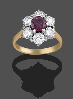 Lot 2077 - An 18 Carat Gold Ruby and Diamond Cluster Ring, the round cut ruby within a border of round...