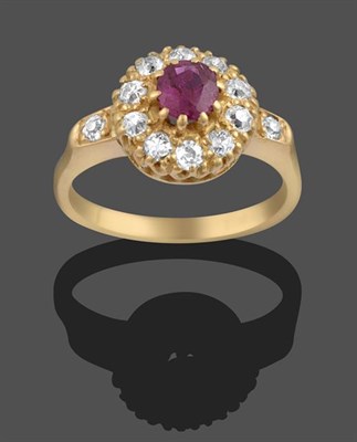 Lot 2078 - A Ruby and Diamond Cluster Ring, the round cut ruby within a border of old cut diamonds, in...