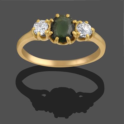 Lot 2082 - A Green Glass and Diamond Three Stone Ring, the oval cut green glass flanked by two old cut...