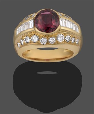 Lot 2089 - A Garnet and Diamond Ring, the oval cut garnet sits between graduated baguette cut diamonds, in...