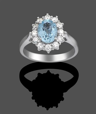 Lot 2105 - An 18 Carat White Gold Aquamarine and Diamond Cluster Ring, an oval cut aquamarine within a...