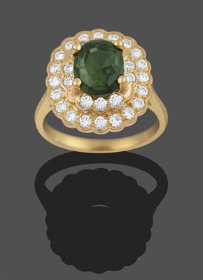 Lot 2126 - A Green Zircon and Diamond Cluster Ring, the oval green zircon in a yellow four claw setting,...
