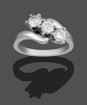 Lot 2146 - An 18 Carat White Gold Diamond Three Stone Twist Ring, the round brilliant cut diamonds in claw...