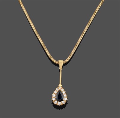 Lot 2157 - An 18 Carat Gold Sapphire and Diamond Pendant on Chain, the pear cut sapphire within a border...