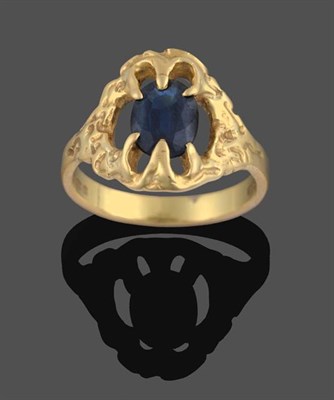 Lot 2196 - An 18 Carat Gold Sapphire Ring, the oval cut sapphire in a fancy yellow claw setting, to a textured