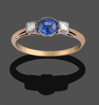 Lot 2197 - A Sapphire and Diamond Three Stone Ring, the round cut sapphire flanked by two princess cut...