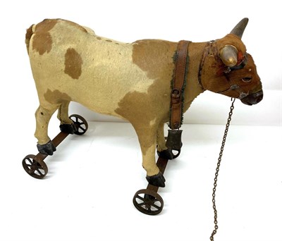 Lot 2001 - Late 19th Century Pull Along Cow, possibly German, with hide covered body, real horns, glass...