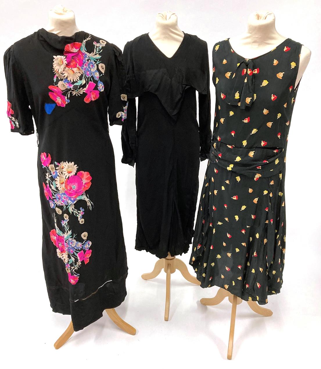 Lot 2035 - Circa 1920/30s Evening Dresses, comprising a black silk sleeveless dress with drop waist,...