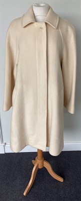 Lot 2065 - A Burberrys Lady's Cream Wool Knee-Length Coat, 1980s/1990s, with concealed button fastening...