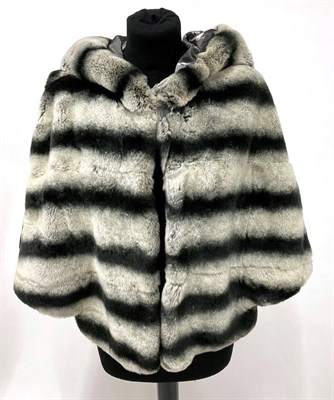 Lot 2085 - A Chinchilla Rex Fur Grey Capelet Style Hooded Jacket, striped in dove and charcoal grey, with...