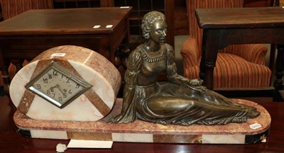 Lot 198 - An Art Deco pink marble striking mantle clock with figure of a seated lady