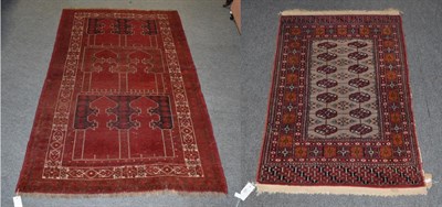 Lot 326 - A Bokhara style rug with a red brick field, 123cm by 77cm and a Balouch rug, 210cm by 120cm (2)