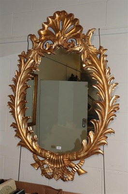 Lot 345 - ^ A reproduction gilt framed oval mirror in the Rococo taste