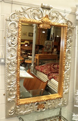 Lot 366 - ^ A reproduction silver and gilt hall mirror with ornate scrolling leaf decoration