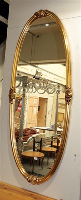 Lot 374 - ^ A large reproduction gilt framed oval hall mirror