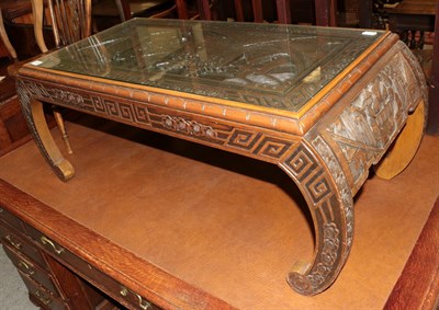 Lot 426 - A 20th century Chinese carved hardwood coffee table with glass top