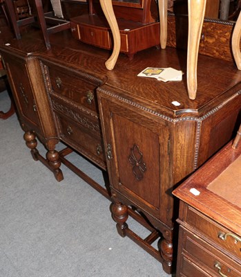 Lot 428 - ^ A 1930's carved oak inverted breakfront sideboard, with egg and dart decoration, turned legs...