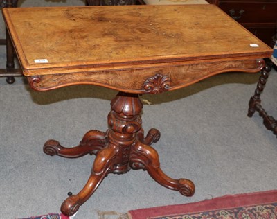 Lot 449 - A 19th century burr walnut fold-over card table, raised on a lotus carved standard and down...