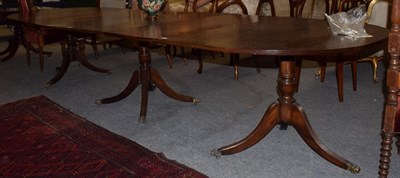 Lot 453 - A mahogany 12' triple pillar D-end dining table, with two additional leaves and brass paw feet...