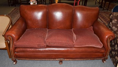 Lot 463 - ^ A modern red leather three-seater sofa with studded decoration