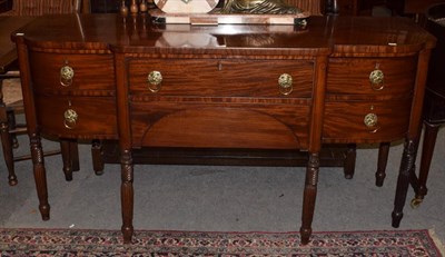 Lot 469 - A Georgian style mahogany breakfront sideboard, raised on fluted and turned cylindrical legs,...