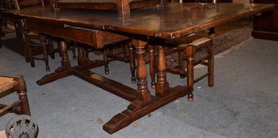 Lot 472 - A reproduction Titchmarsh & Goodwin oak extending dining table on trestle base