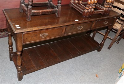 Lot 475 - A reproduction Titchmarsh & Goodwin oak dresser base fitted with three drawers, the legs joined...