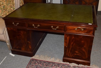 Lot 516 - A reproduction mahogany desk with green leather writing surface, 145cm wide