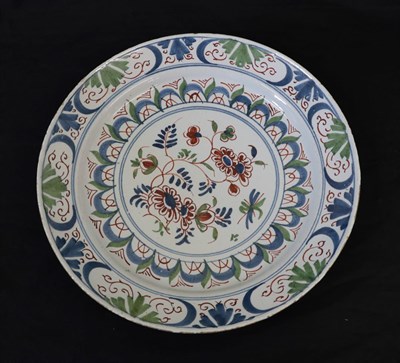 Lot 24 - An English Delft Plate, mid 18th century, painted in colours with a central flowerspray within...